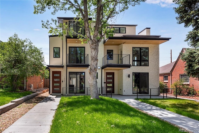 contemporary home featuring a front yard and a balcony