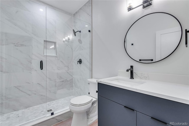 bathroom with vanity, an enclosed shower, and toilet