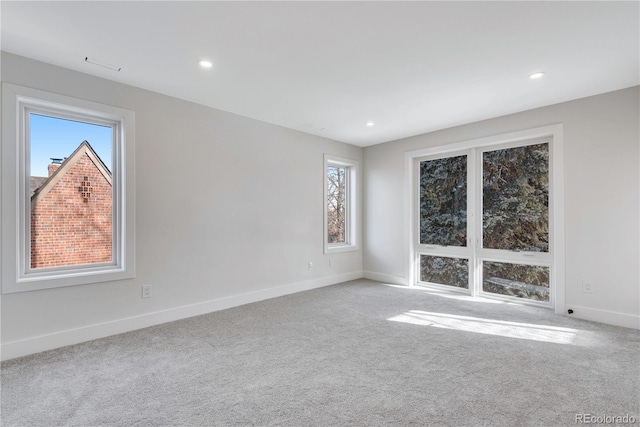 unfurnished room with a wealth of natural light and light carpet