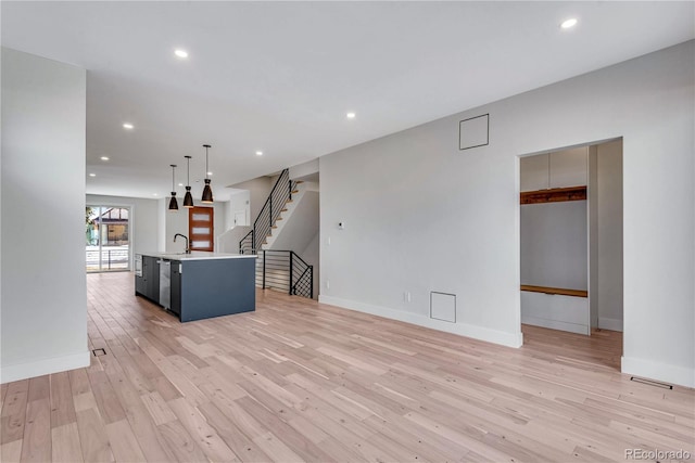 unfurnished living room with sink and light wood-type flooring