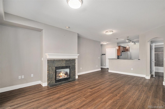 9039 E Panorama Cir Unit C201, Englewood, CO 80112 - unfurnished living room featuring dark wood-type flooring, a tile fireplace, and arched walkways