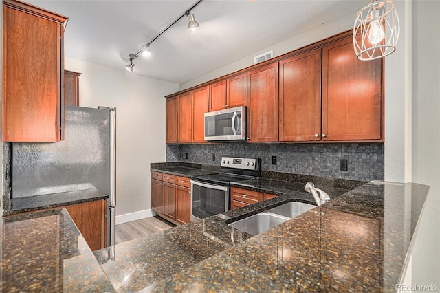 9039 E Panorama Cir Unit C201, Englewood, CO 80112 - kitchen with appliances with stainless steel finishes, decorative backsplash, light wood finished floors, and dark stone countertops