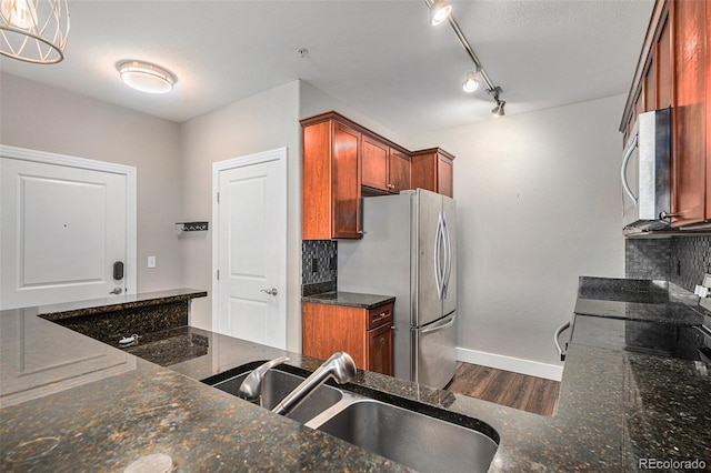 9039 E Panorama Cir Unit C201, Englewood, CO 80112 - kitchen with stainless steel appliances, dark wood finished floors, decorative backsplash, and dark stone countertops