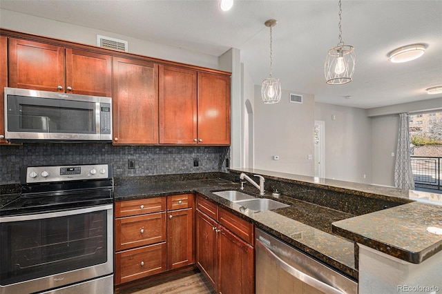 9039 E Panorama Cir Unit C201, Englewood, CO 80112 - kitchen with stainless steel appliances, dark stone counters, backsplash, and light wood-style flooring