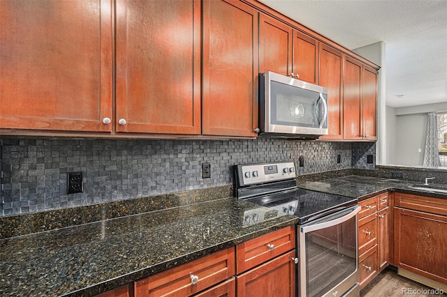 9039 E Panorama Cir Unit C201, Englewood, CO 80112 - kitchen with appliances with stainless steel finishes, tasteful backsplash, wood finished floors, and dark stone countertops