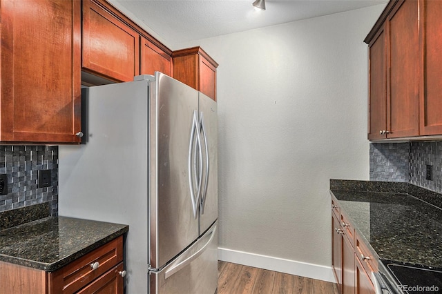 9039 E Panorama Cir Unit C201, Englewood, CO 80112 - kitchen with appliances with stainless steel finishes, dark wood-style flooring, backsplash, and dark stone counters