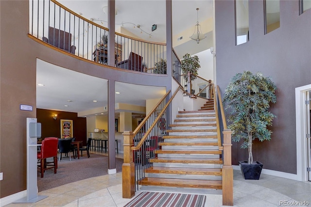 9039 E Panorama Cir Unit C201, Englewood, CO 80112 - stairway featuring tile patterned floors, a towering ceiling, and carpet
