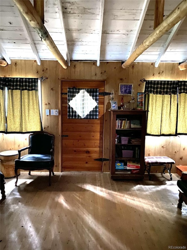 10504 Jackson Creek Rd, Sedalia, CO 80135 - living area featuring wood-type flooring, beam ceiling, and wooden walls