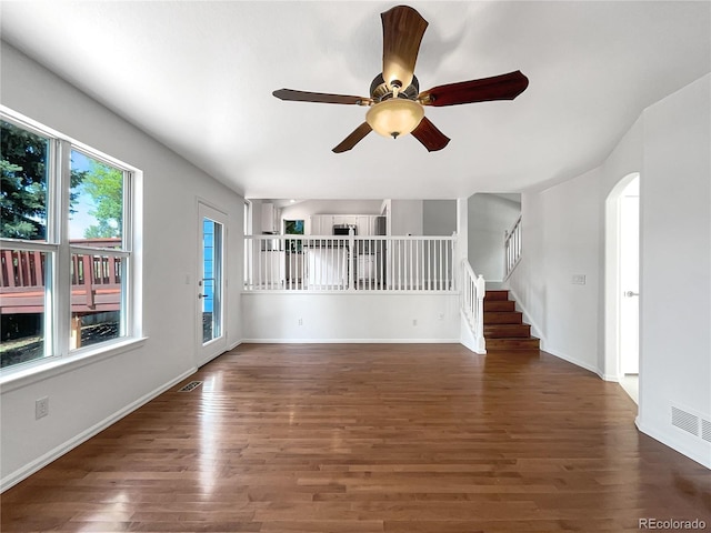 5005 W 128th Pl, Broomfield, CO 80020 - unfurnished living room featuring wood finished floors, ceiling fan, stairway, and arched walkways