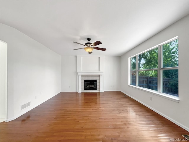 5005 W 128th Pl, Broomfield, CO 80020 - unfurnished living room with ceiling fan, a tiled fireplace, and light wood finished floors