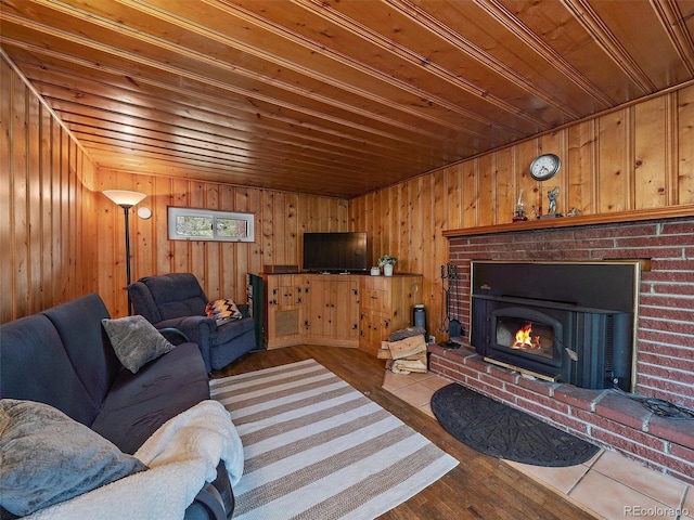 living room featuring wooden ceiling, a fireplace, wood walls, and light hardwood / wood-style flooring