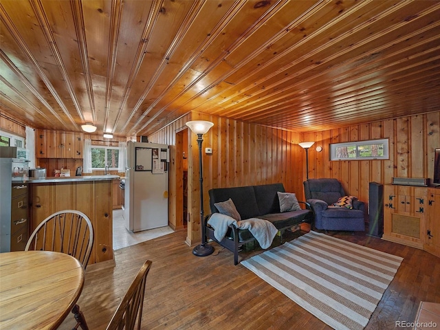 living room with wood walls, wooden ceiling, and dark wood-type flooring