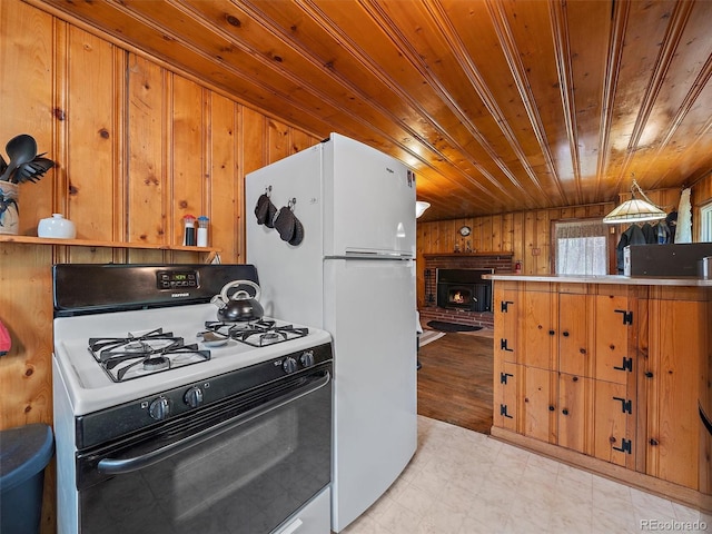 kitchen with kitchen peninsula, white appliances, wooden walls, decorative light fixtures, and wooden ceiling