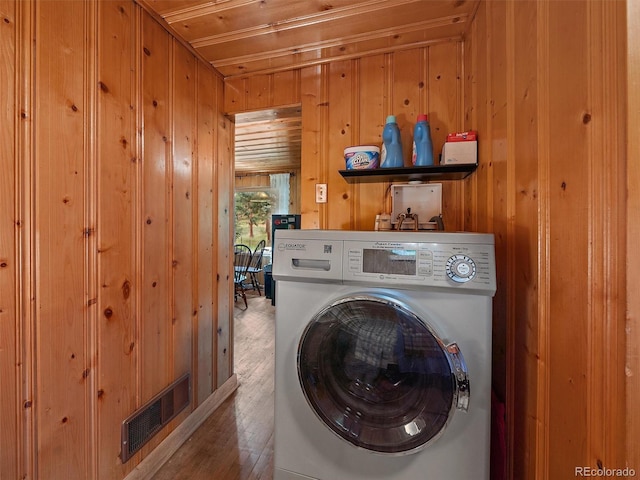 laundry room with wood ceiling, wood walls, hardwood / wood-style floors, and washer / dryer