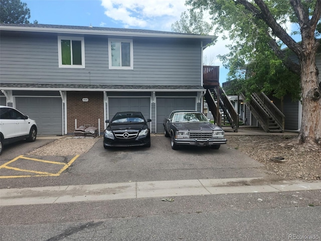 7925 York St Unit 2, Denver, CO 80229 - view of front of property featuring stairs, driveway, a garage, and brick siding