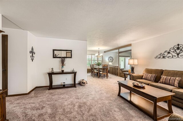 678 S Oswego Ct, Aurora, CO 80012 - carpeted living area with a chandelier, a textured ceiling, and baseboards