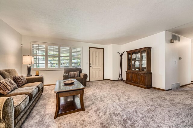 678 S Oswego Ct, Aurora, CO 80012 - carpeted living area featuring baseboards and a textured ceiling