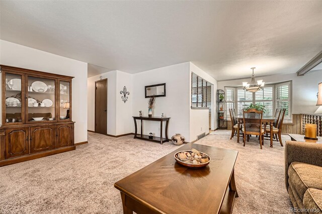 678 S Oswego Ct, Aurora, CO 80012 - living room featuring light carpet, a chandelier, and baseboards