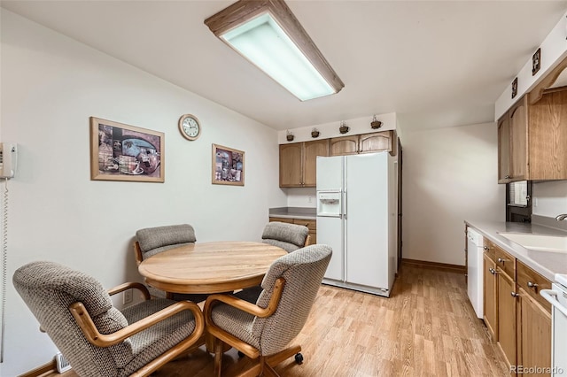 678 S Oswego Ct, Aurora, CO 80012 - kitchen featuring white appliances, a sink, light wood finished floors, light countertops, and baseboards