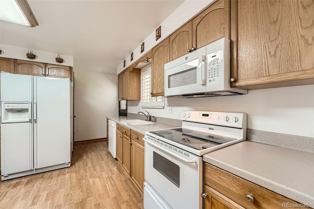 678 S Oswego Ct, Aurora, CO 80012 - kitchen with white appliances, a sink, light wood-type flooring, and light countertops