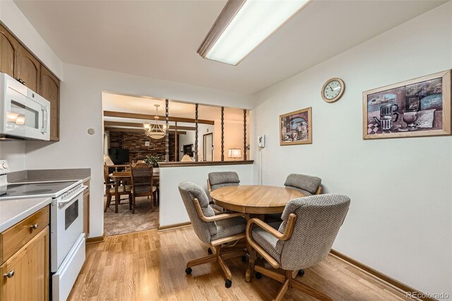 678 S Oswego Ct, Aurora, CO 80012 - dining space featuring light wood-style flooring, a chandelier, and baseboards