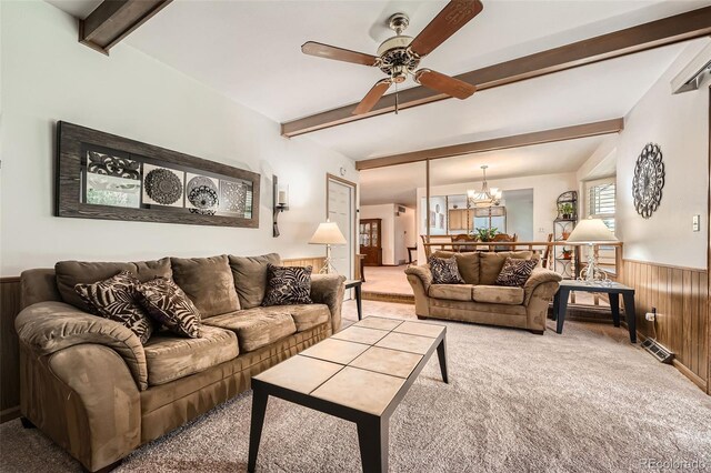 678 S Oswego Ct, Aurora, CO 80012 - living room featuring light colored carpet, beamed ceiling, a ceiling fan, a wainscoted wall, and a chandelier