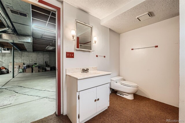 678 S Oswego Ct, Aurora, CO 80012 - bathroom featuring toilet, vanity, and a textured ceiling