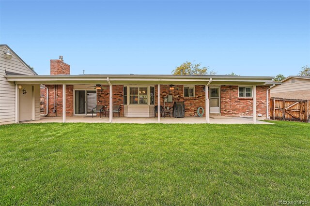 678 S Oswego Ct, Aurora, CO 80012 - back of property featuring a ceiling fan, a patio, a chimney, and brick siding