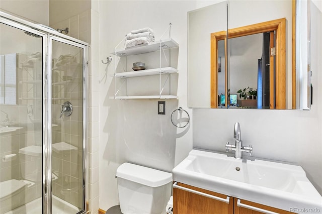 bathroom with vanity, a shower with shower door, and toilet