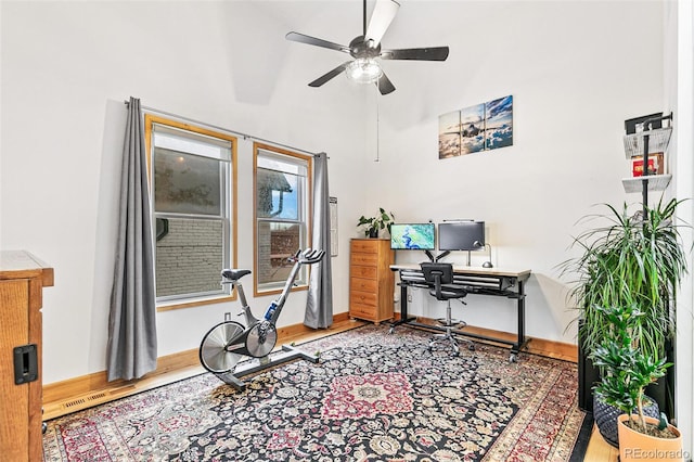 office space with hardwood / wood-style flooring, ceiling fan, and a high ceiling