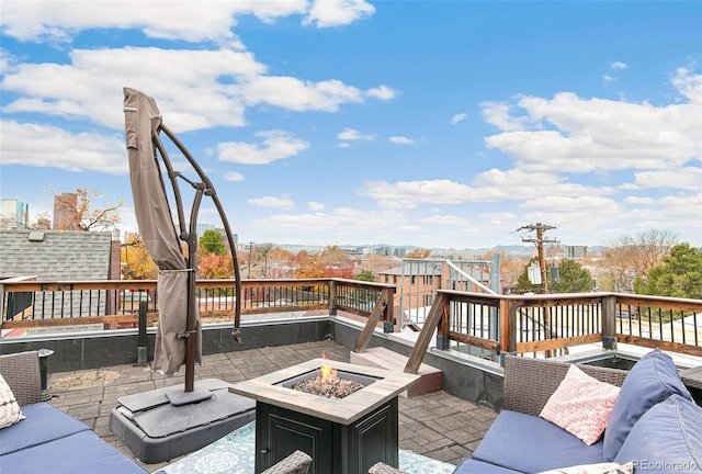 wooden terrace with a patio and an outdoor living space with a fire pit