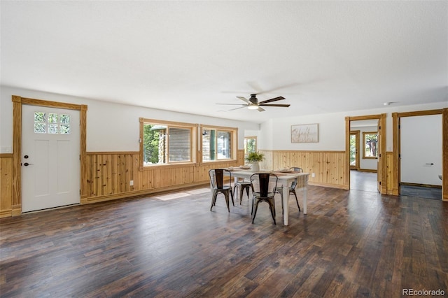 dining area featuring dark wood finished floors, wainscoting, and a healthy amount of sunlight