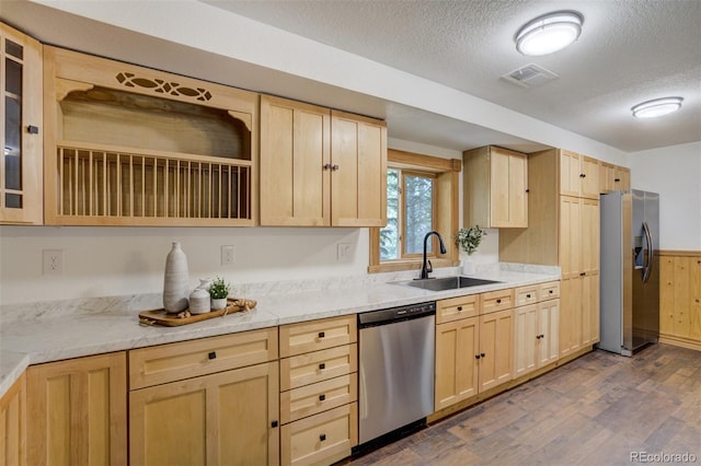 kitchen with stainless steel appliances, a sink, and light brown cabinets
