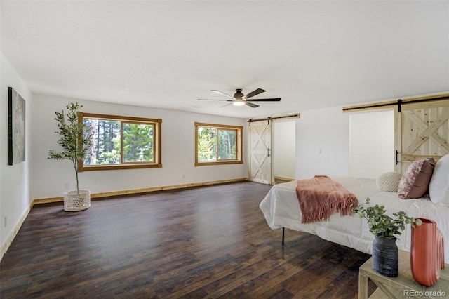 bedroom featuring baseboards, a barn door, ceiling fan, and wood finished floors