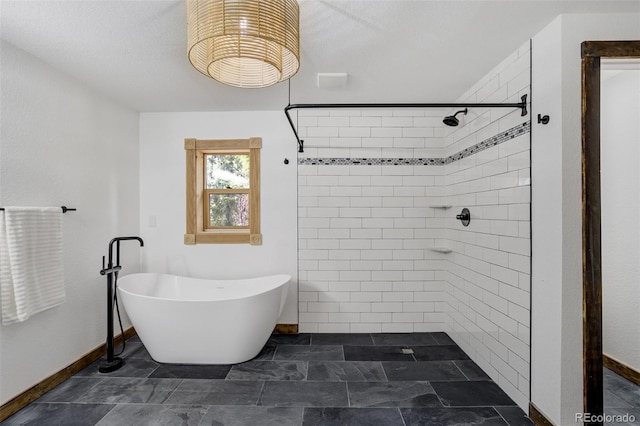 full bath featuring a freestanding tub, baseboards, and tiled shower