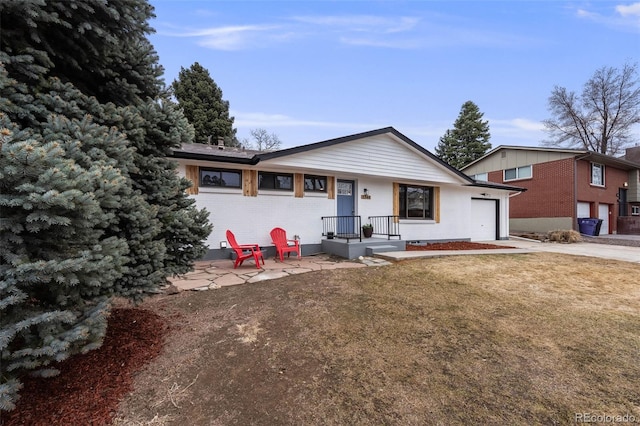 ranch-style house with a garage, concrete driveway, brick siding, and a front lawn