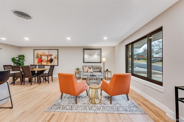 living area featuring light wood-style floors, baseboards, visible vents, and recessed lighting