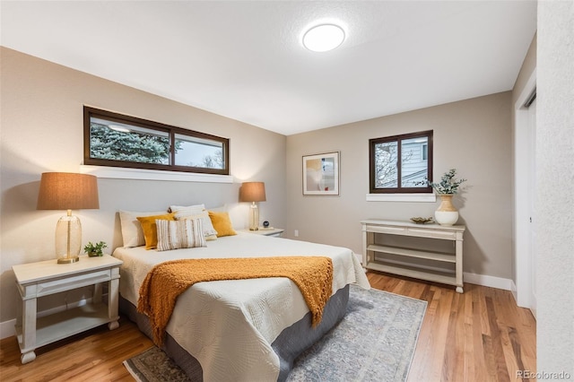 bedroom with light wood-style flooring and baseboards