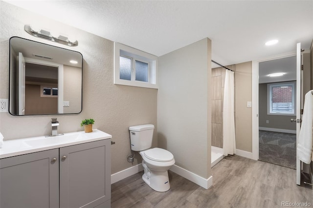 full bathroom with baseboards, toilet, wood finished floors, curtained shower, and vanity