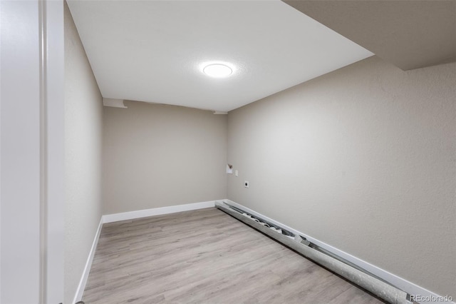 spare room with baseboards and wood finished floors