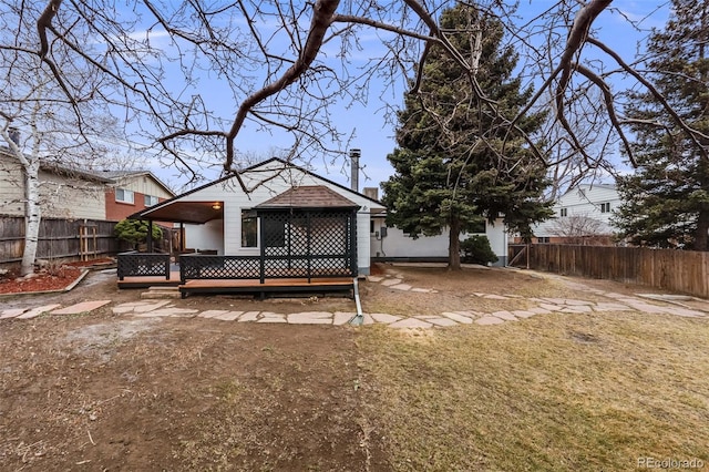 rear view of property with a fenced backyard and a deck