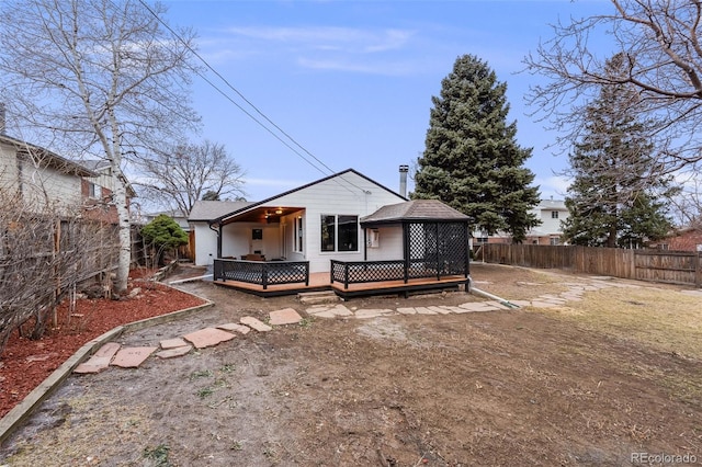 rear view of house featuring a shingled roof, a fenced backyard, and a wooden deck