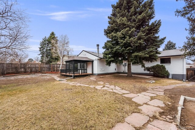 back of house featuring a fenced backyard, a lawn, and a gazebo