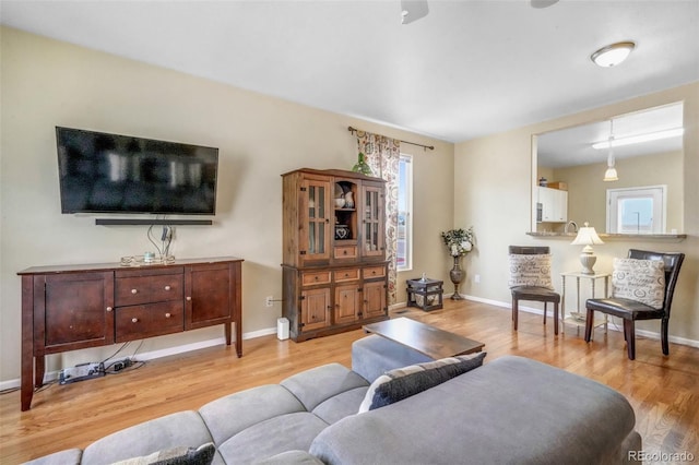 living room with light wood-style flooring and baseboards