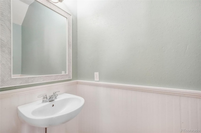 bathroom featuring wainscoting and a sink
