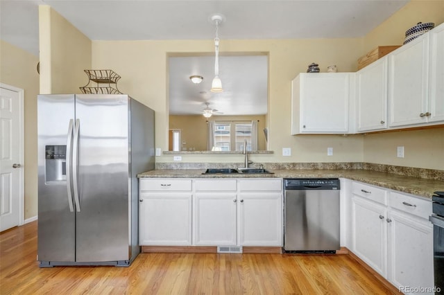 kitchen with a sink, white cabinets, a ceiling fan, and stainless steel appliances