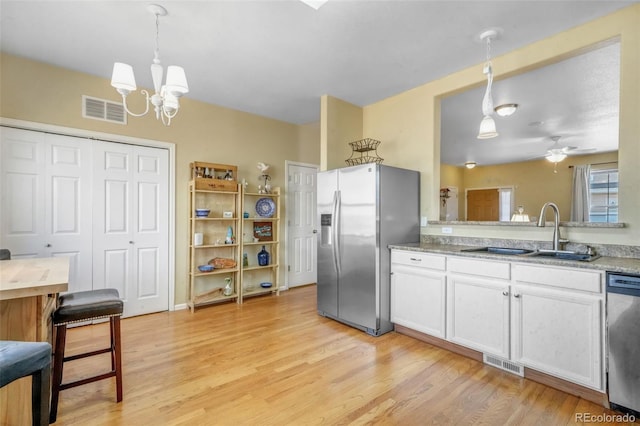 kitchen featuring a sink, visible vents, appliances with stainless steel finishes, and light wood finished floors