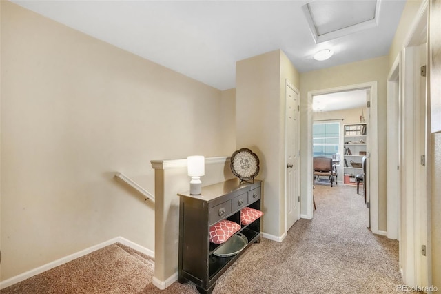 hall featuring carpet, an upstairs landing, and baseboards