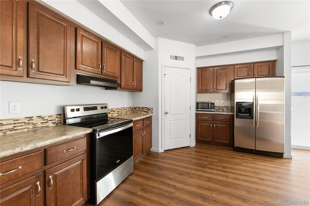 kitchen featuring stainless steel appliances, light stone counters, backsplash, and dark hardwood / wood-style flooring