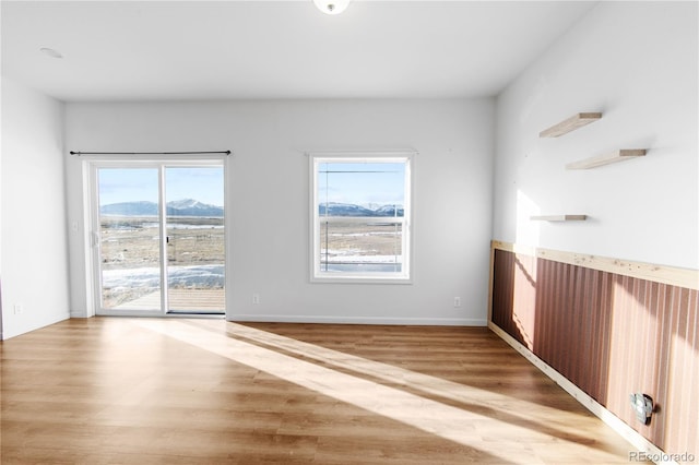 unfurnished room featuring hardwood / wood-style flooring and a mountain view